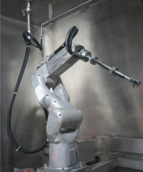 A robotic arm in a metallic enclosure, equipped with a precision tool at the end, is connected to cables for power and control. The setup appears industrial, likely for manufacturing or automated processes.
